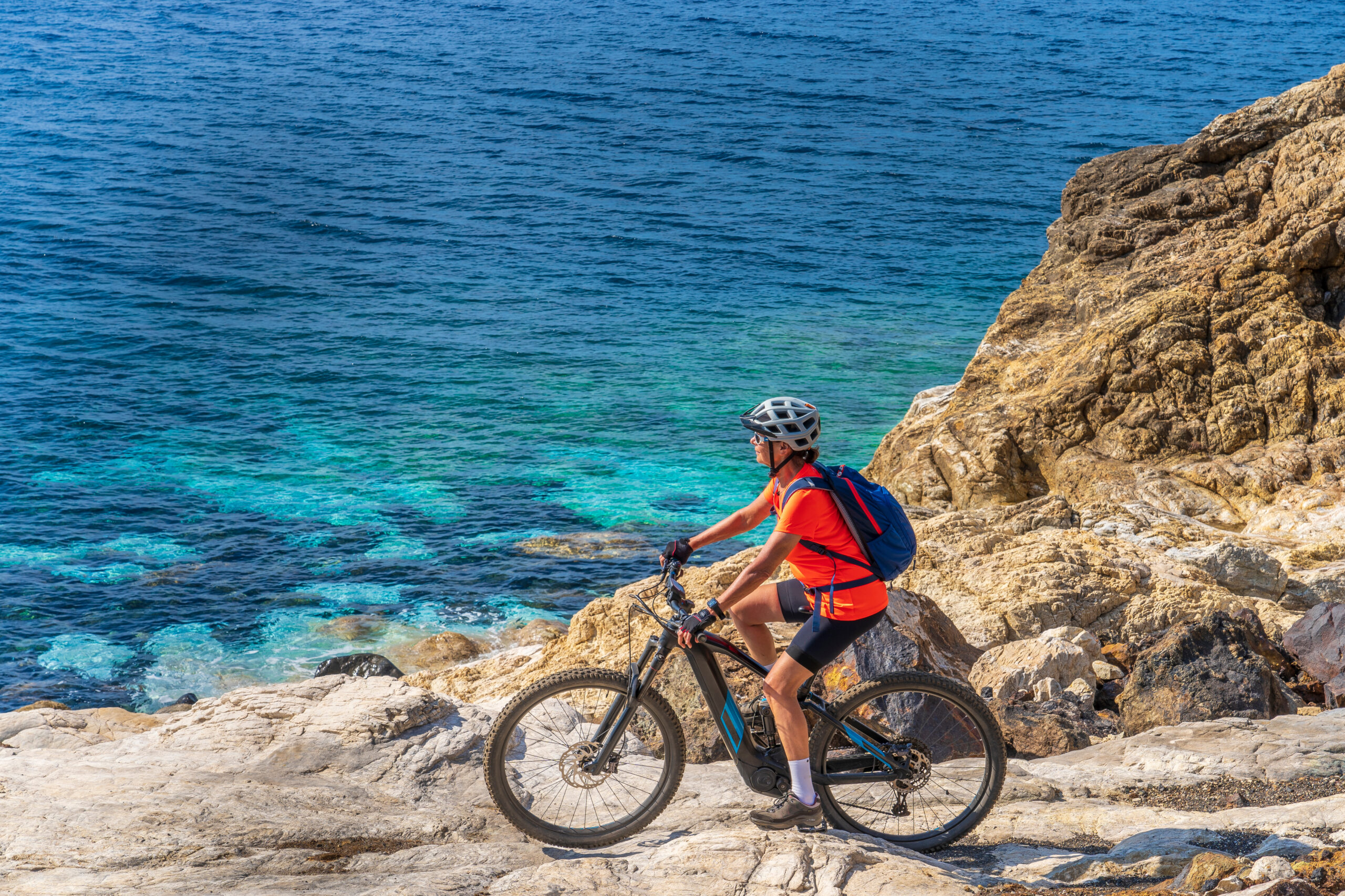 Mountainbiker an der felsigen Küste von Elba mit türkisfarbenem Meer