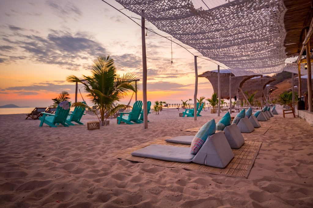 Beach club with chairs and umbrellas on beach during sunset