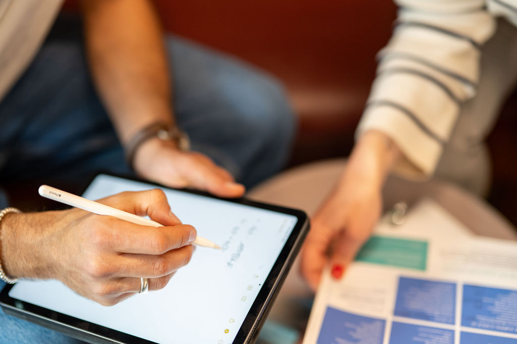 Zwei Personen mit Tablet und Katalog bei Eventplanung.