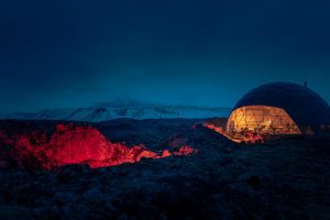 Glamping Zelt in der Nacht und im Schnee mit Beleuchtung.