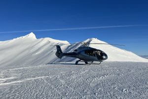Helikopter im Schnee, blauer Himmel.