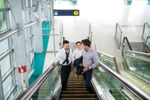 3 Business Leute auf Rolltreppe am Flughafen.