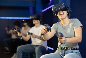 Gruppe von Leuten sitzend mit VR Brillen in einem Raum.