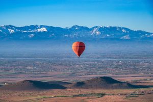 Roter Heißluftballon über der Wüste,