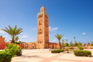 Die Koutoubia-Moschee in Marrakesch, eines der bekanntesten Wahrzeichen der Stadt, umgeben von Gärten und traditioneller marokkanischer Architektur.