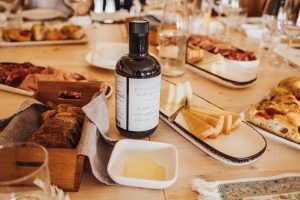 Gedeckter Tisch mit Olivenöl und mediterranen Speisen, der traditionelle Küche und eine genussvolle Atmosphäre widerspiegelt.