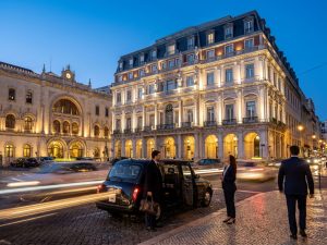 Beleuchtete historische Fassade eines Luxushotels im Zentrum von Lissabon bei Abenddämmerung