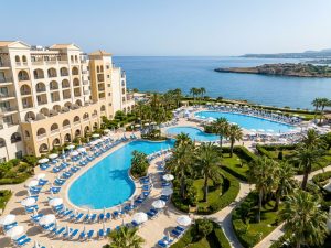Strandresort auf Malta mit mehreren Pools und Palmen direkt am Meer