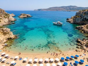 Felsige Küste auf Malta mit türkisfarbenem Wasser und Boot