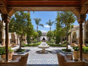 KI-generierte Visualisierung eines marokkanischen Riad-Innenhofs mit Brunnen, Mosaikfliesen und Palmen, typisch für Boutique-Locations bei Firmen-Offsites in Marrakesch