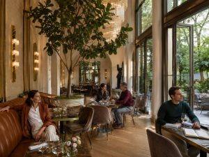 Stilvoller Restaurantbereich mit Pflanzen und Sitzgelegenheiten in einem Hotel in München