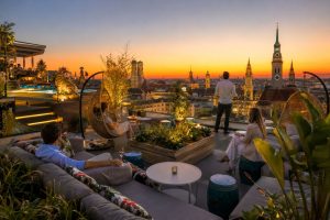 Dachterrasse eines Hotels in München mit Blick auf die Stadt bei Sonnenuntergang