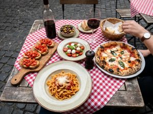 Toskanische Spezialitäten wie Bruschetta, Käse und Wein auf einem gedeckten Tisch