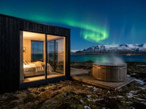 Zimmer eines Boutique-Hotels in Island mit Blick auf das Nordlicht über dem Wasser