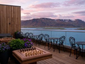 Restaurant mit Holzterrasse und Blick auf Berge und Wasser in Island